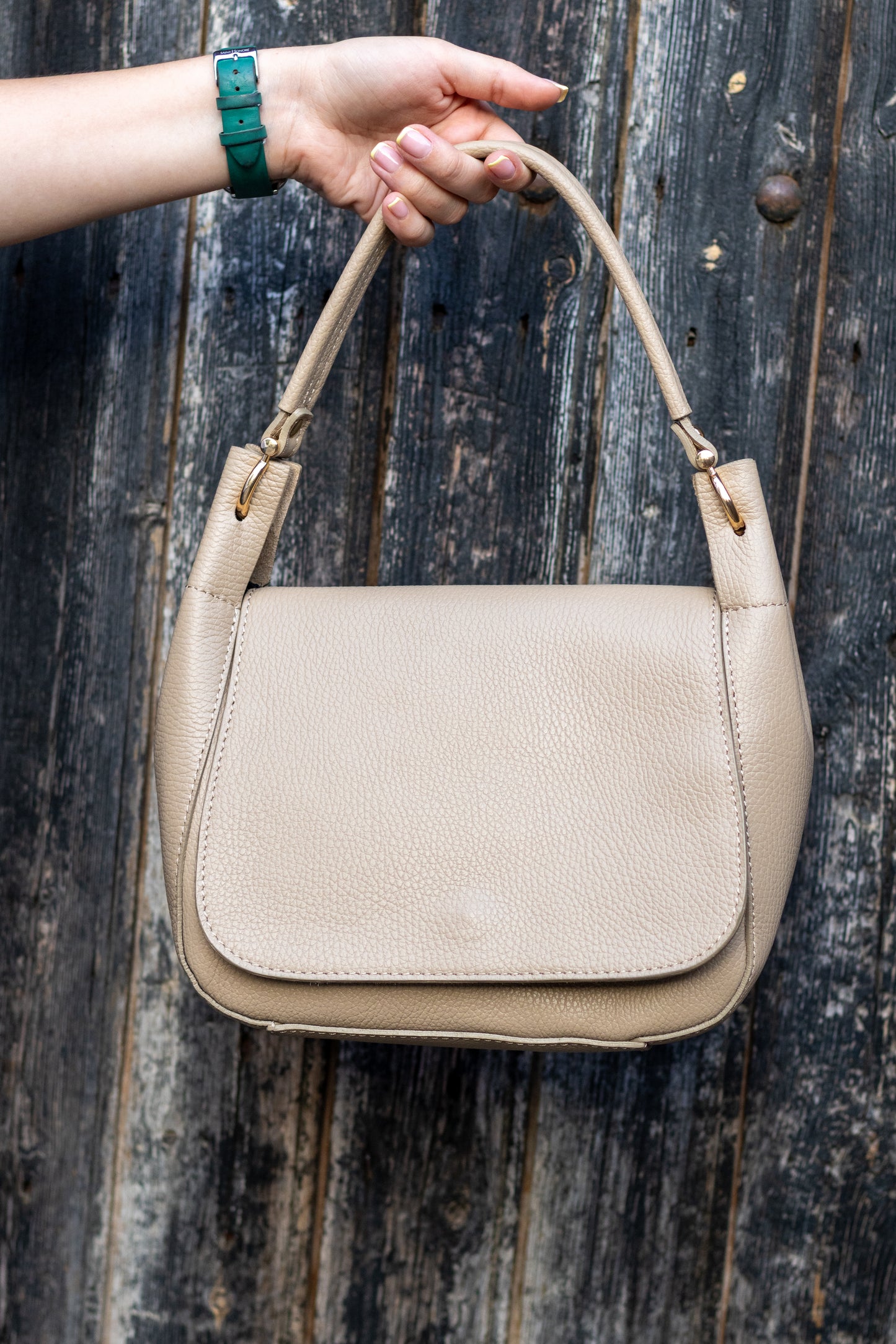 Sac Naomi cappuccino suspendu à la main – ambiance urbaine, cuir grainé visible